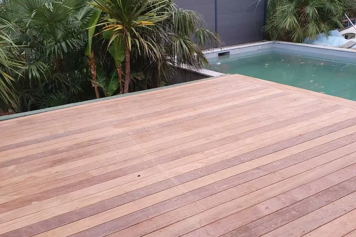 Terrasse en bois exotique autour d'une piscine, réalisée par BATI ZINC 31